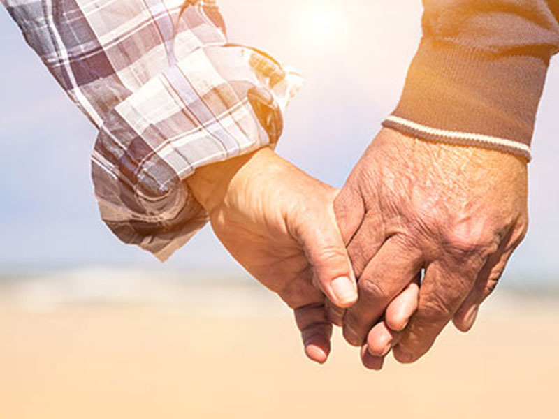 An older couple holding hands because age doesn't matter in their relationship.