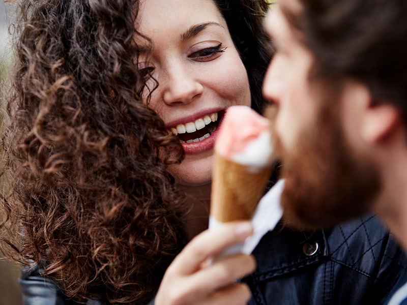 A woman flirting with her date using an ice cream cone.
