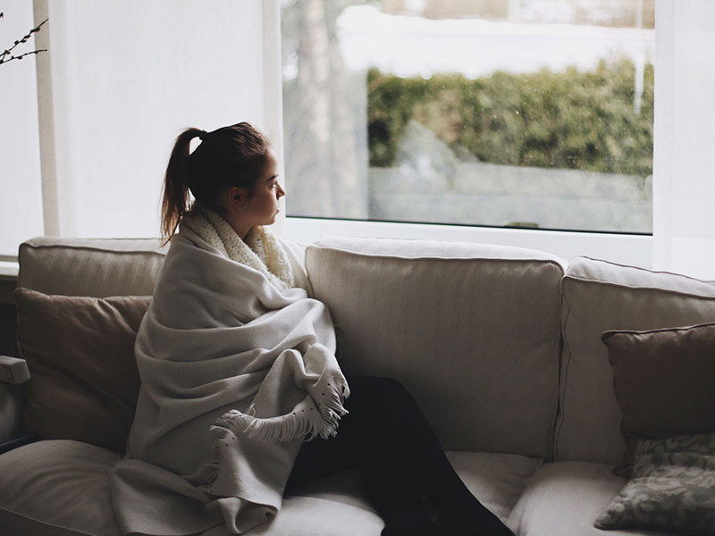 A woman in a long distance relationship looking out the window.