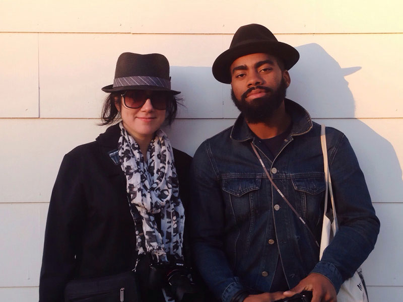 An interracial couple hanging out and smiling.