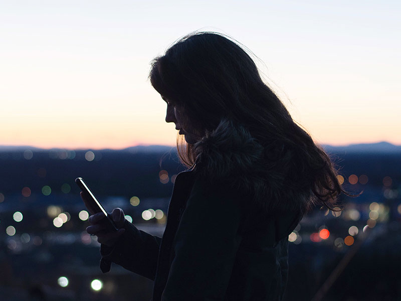 A girl texting while trying to meet someone on an online dating site.