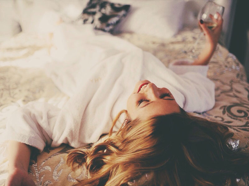A girl drinking wine alone because she's getting over being single and lonely.