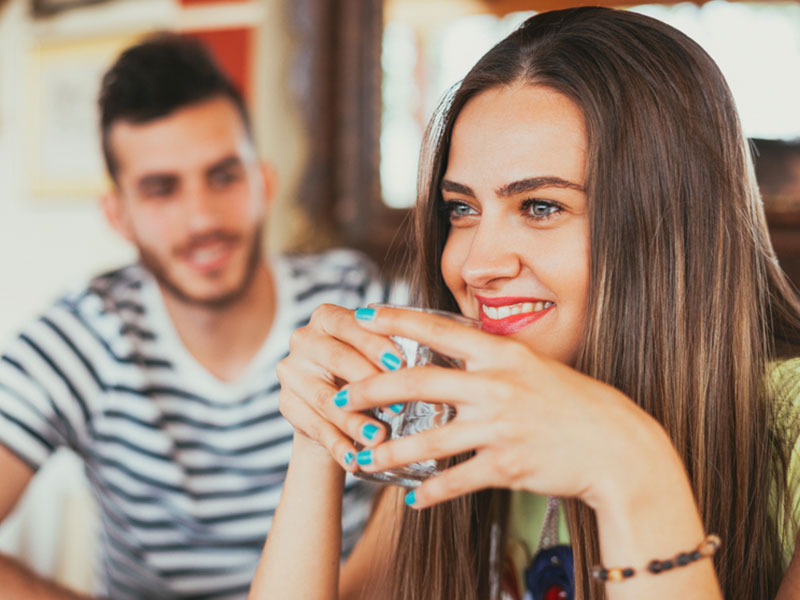 A guy who knows how to ask someone out about to talk to a girl holding a drink.