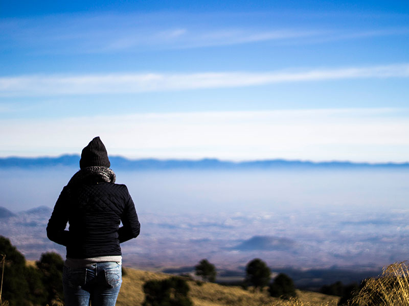 A woman who can't be friends with her ex standing on top of a mountain.