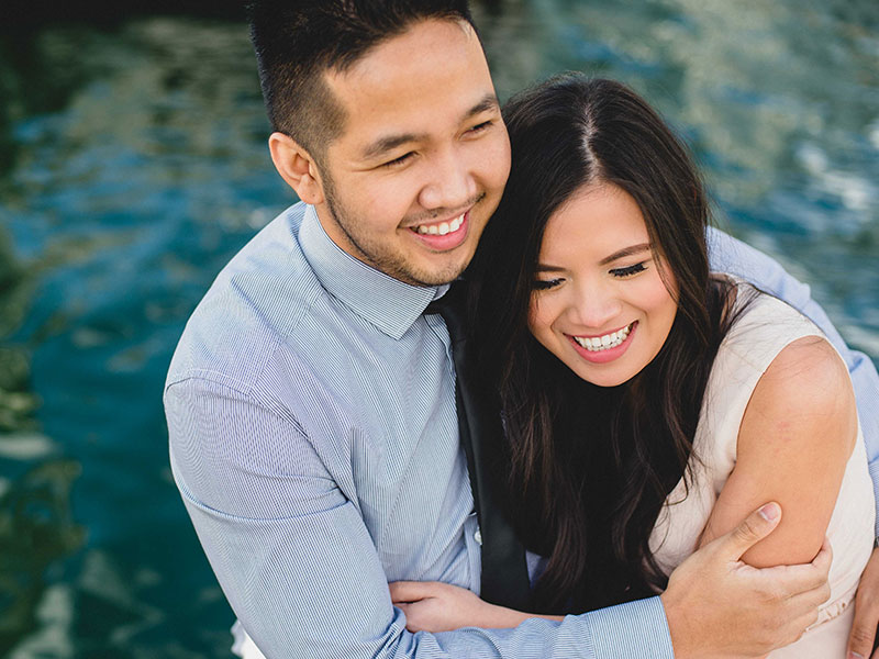 A woman laughing about getting back together with her ex who she's hugging.