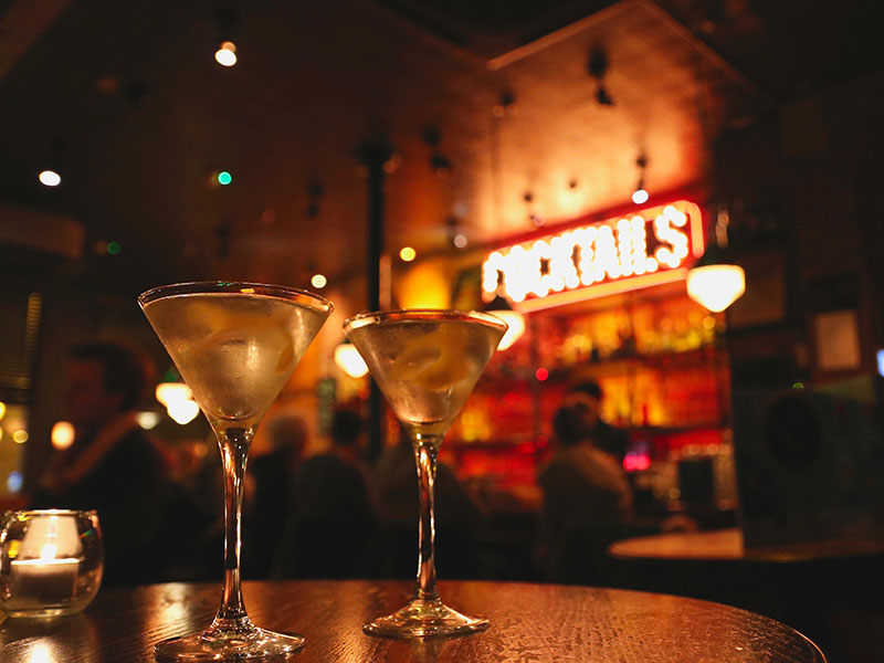 Two cocktails on a table at a bar. Good dating safety means not leaving your drink unattended.
