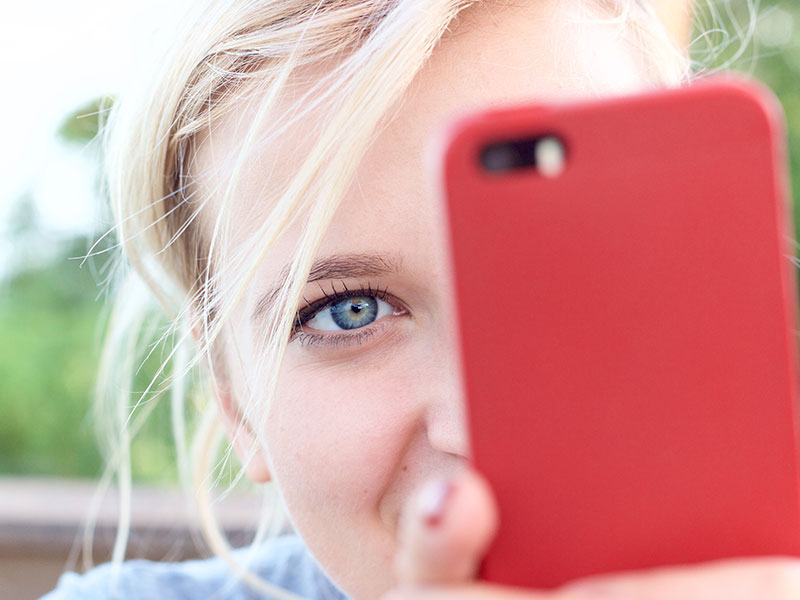 A woman with her phone wondering about online vs. offline attraction.