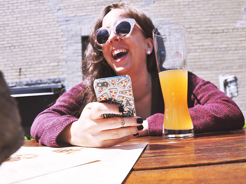 A girl online dating at a bar.