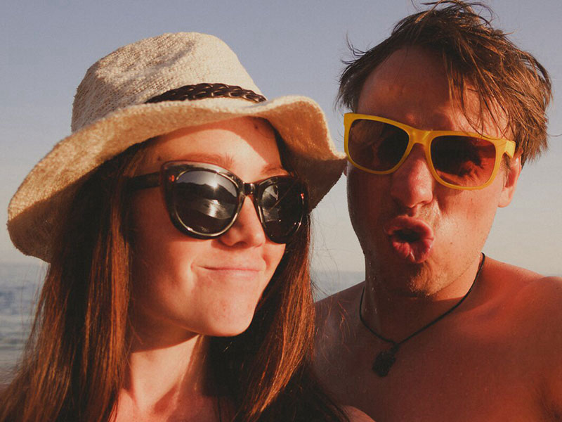A couple laughing and smiling on the beach together.