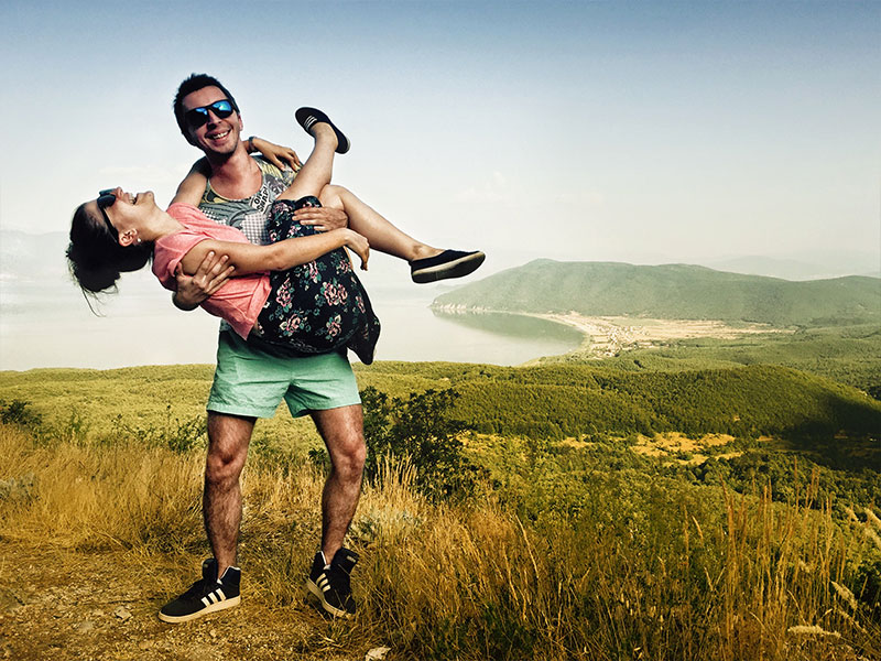 A couple laughing on a hike because they learned how to strengthen your relationship.