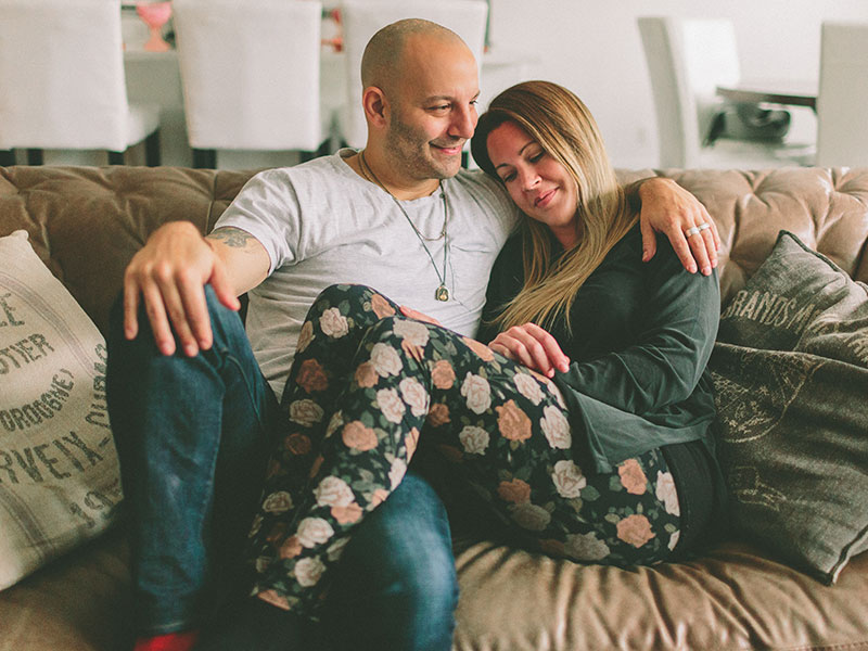 A couple dating over 40 snuggling on the couch.
