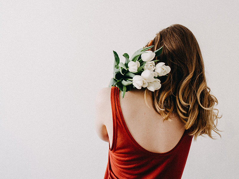 A woman who's single on Valentine's Day holding some flowers she bought for herself.