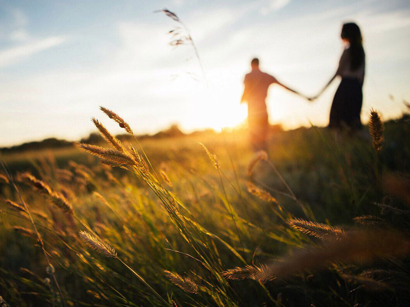 A woman who listened to these dating tips for women over 40 in a field at sunset with her boyfriend.
