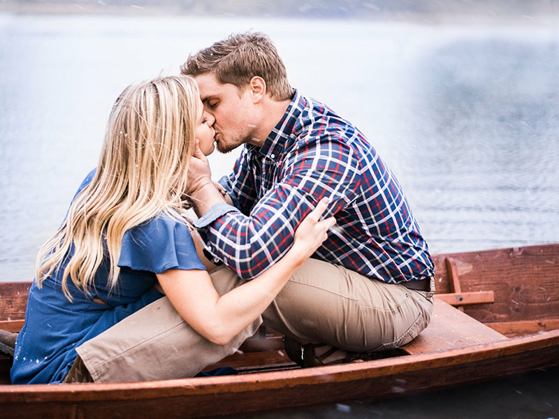 A couple who experienced love at first sight, kissing on a boat during a date.