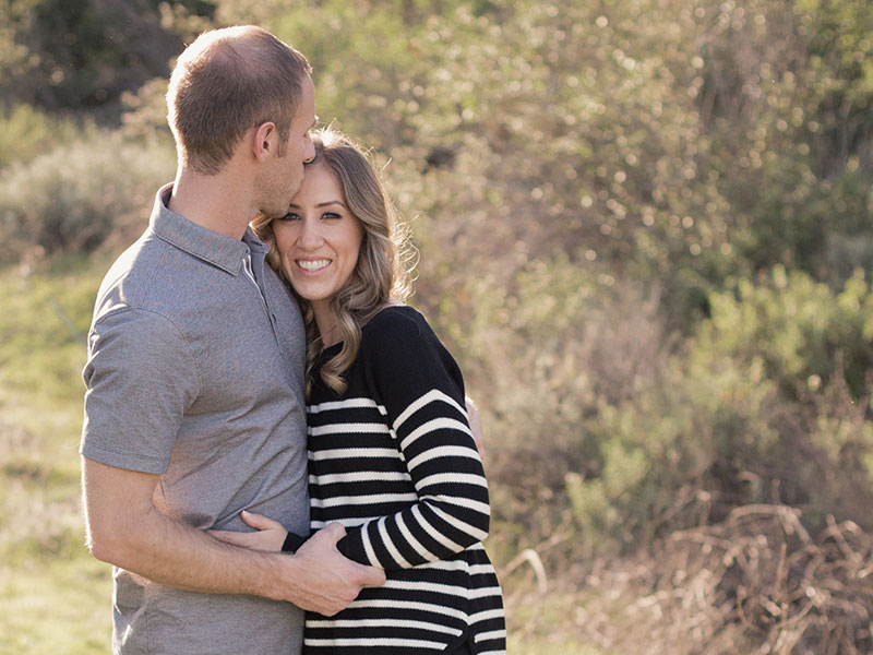 A woman who's single over 40 hugging her boyfriend who she didn't settle for in a sunny field.