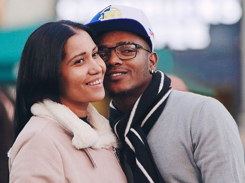 A girl thinking about being single vs. in a relationship smiling with a guy she's on a date with.