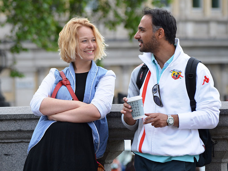 A woman who learned how to start a conversation with someone, chatting with a man she’s attracted to outside.