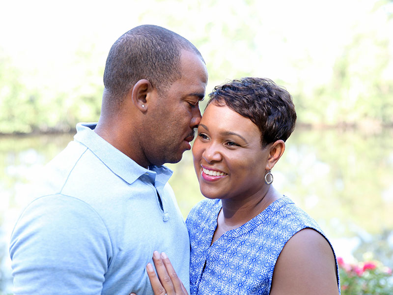 A man and a woman on a date, smiling as they hug each other.
