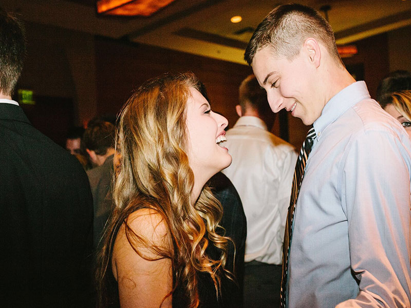 A woman who was wondering what is microcheating, flirting with a coworker at a bar.