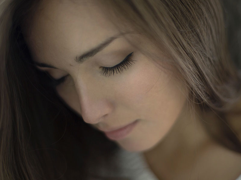 A woman who's feeling unwanted looking down and trying to reassess how she feelings.