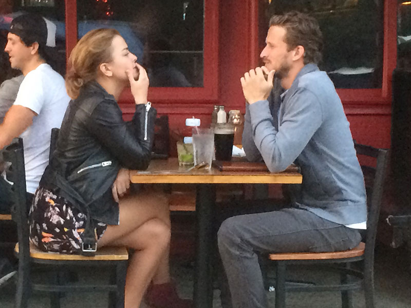 A couple calmly having an argument at a coffee shop.