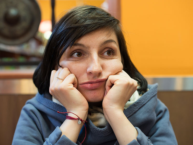 A woman who's bored at a restaurant, wondering if she's going to be single forever.