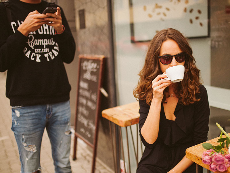 A woman stonewalling her boyfriend in the middle of an argument at a coffeeshop.