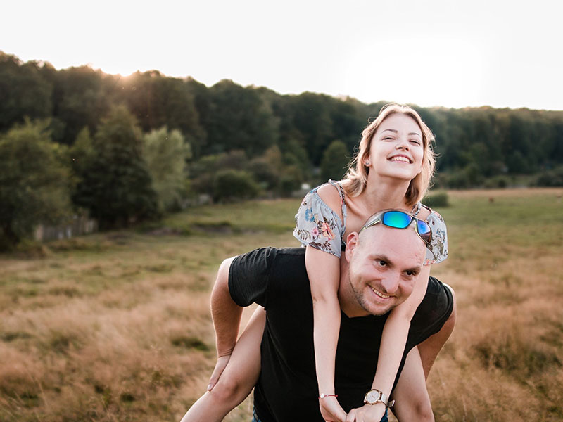 A guy who learned how to be a good boyfriend giving his girlfriend a piggy back ride.
