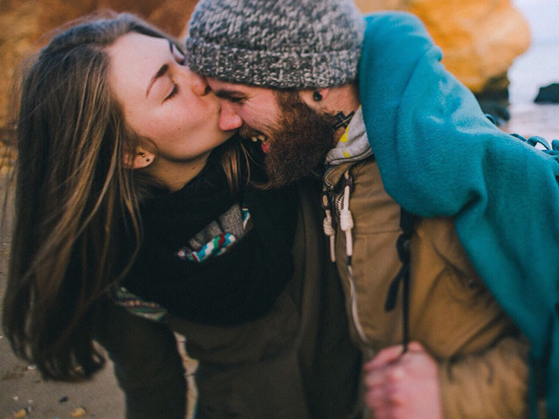 A girl and a guy who used to have bad dating experiences, laughing and kissing on the beach.