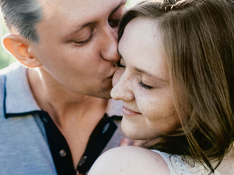 A man and a woman who are single in their 40s, on a date and sharing a kiss.