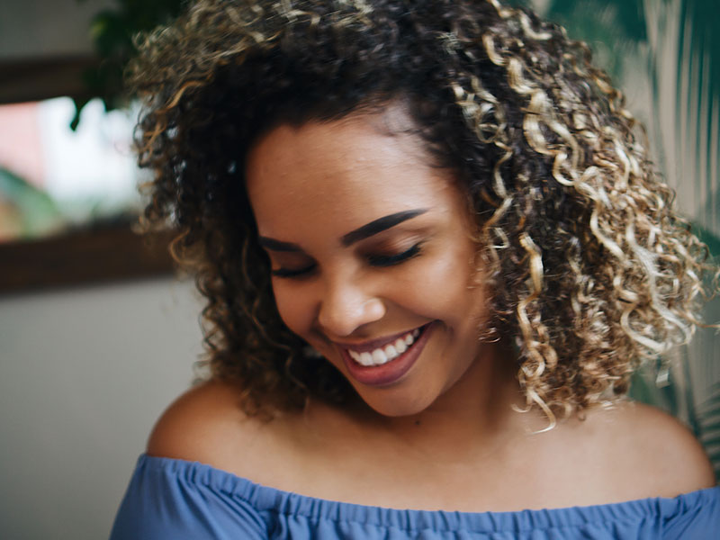 A girl who just realized I love him, smiling and laughing to herself shyly.