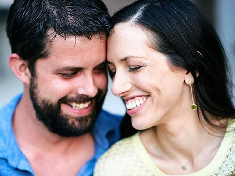 A couple in a serious relationship smiling and laughing with each other.