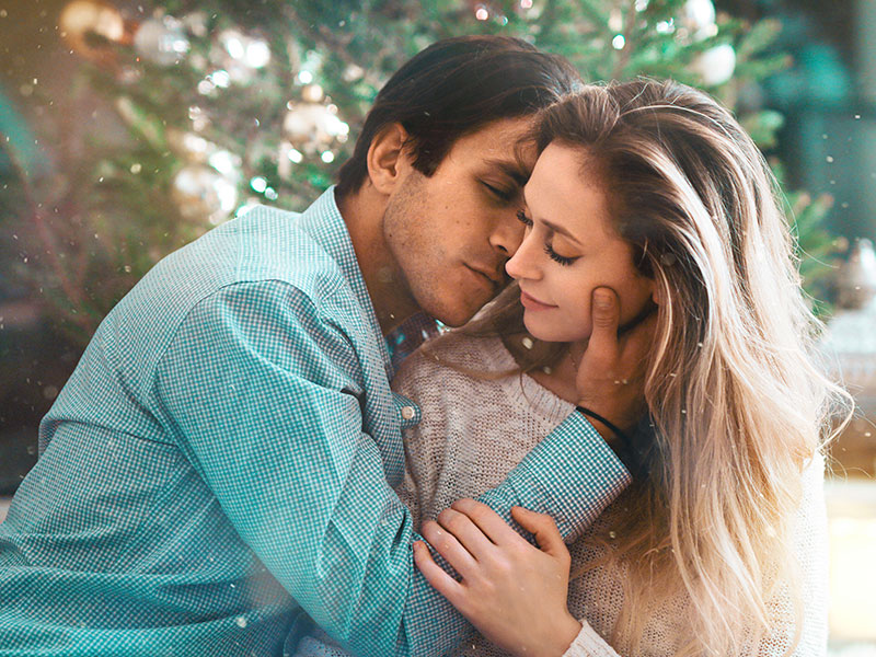 A couple in a complicated relationship kissing with their eyes closed.