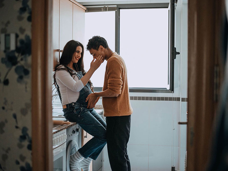 A couple who have experienced many of the different types of love, embracing as the woman is pregnant and the man holds her belly.
