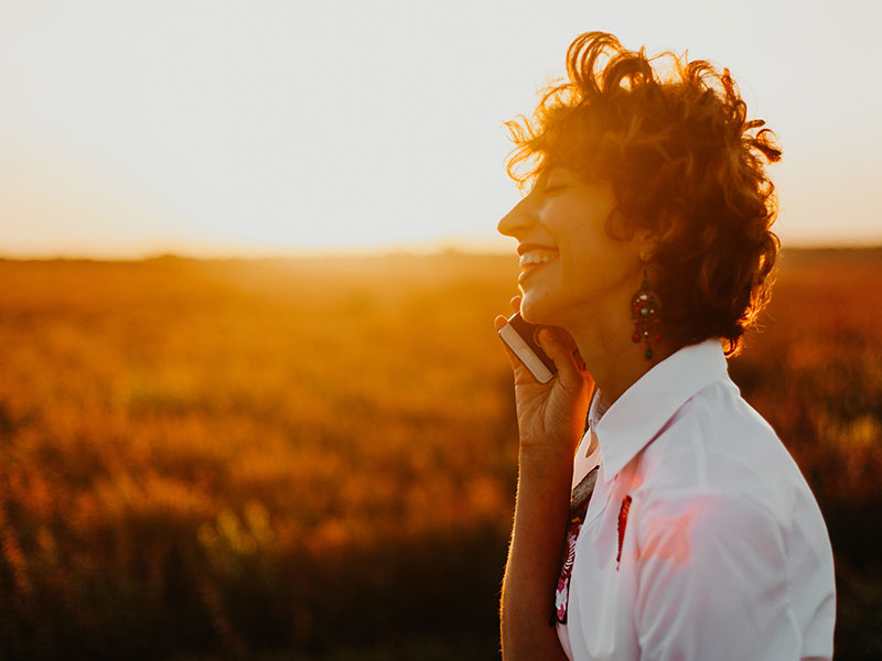 A woman on the phone with her friend, trying to keep the long distance friendship alive even though they're apart.