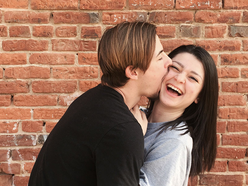 A woman laughing at her boyfriend's corny pick up lines.