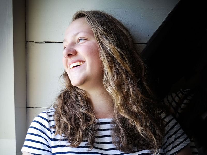 A woman laughing and looking out the window who just started dating after a breakup.