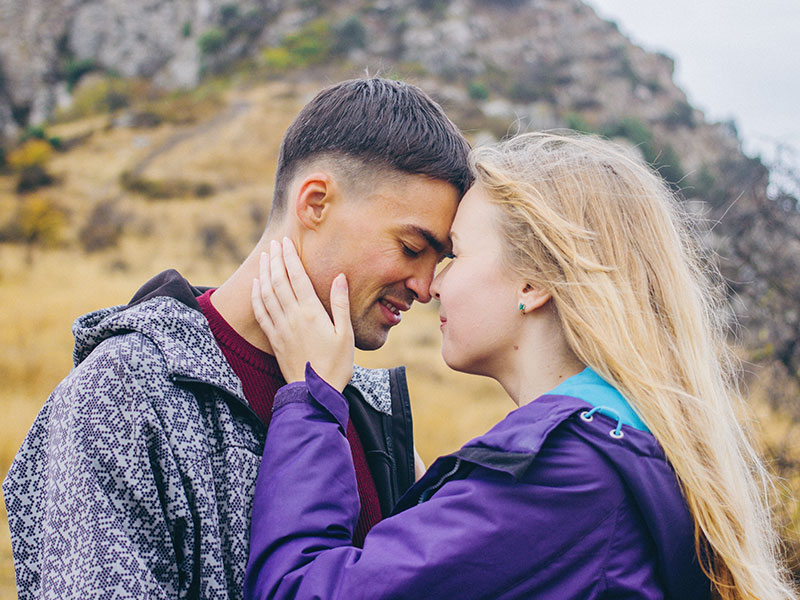 A couple who learned how to be vulnerable in a relationship leaning against each other with their eyes closed.