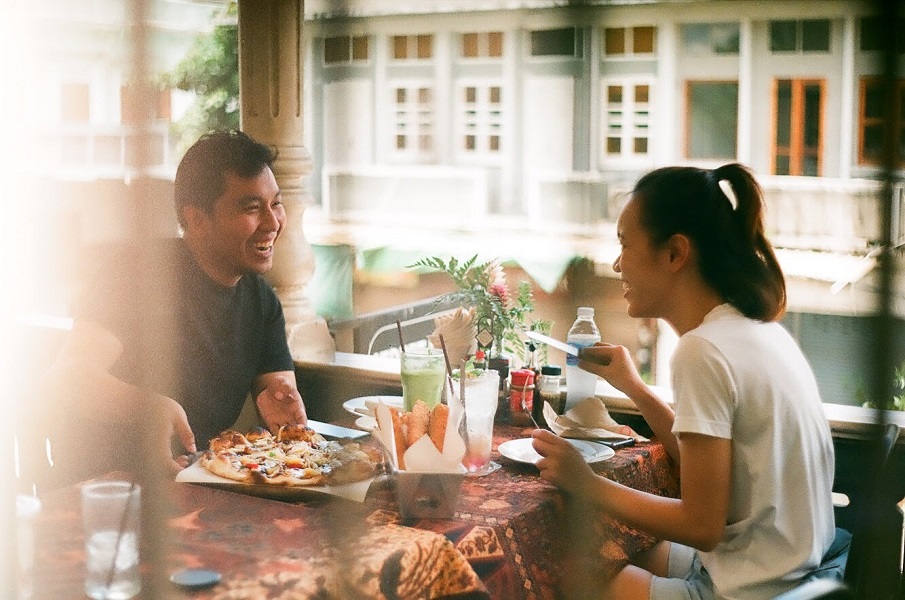 man and woman practicing good first date etiquette while eating pizza