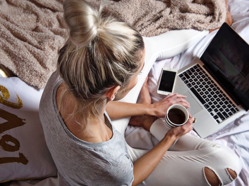Blonde woman using laptop to meet people on good dating sites