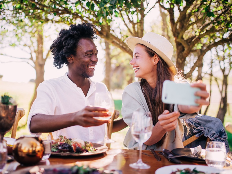 An attractive couple taking a selfie and discussing social media and relationships