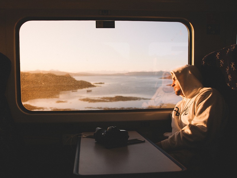 Men staring out train window thinking about should we break up or not