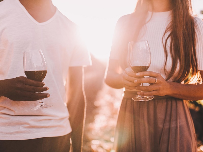 lady and man outside drinking wine with her trying to figure out how to tell if a guy is into you
