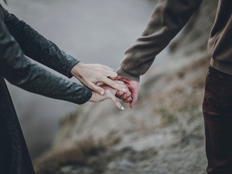 couple holding hands discussing codependent relationship signs