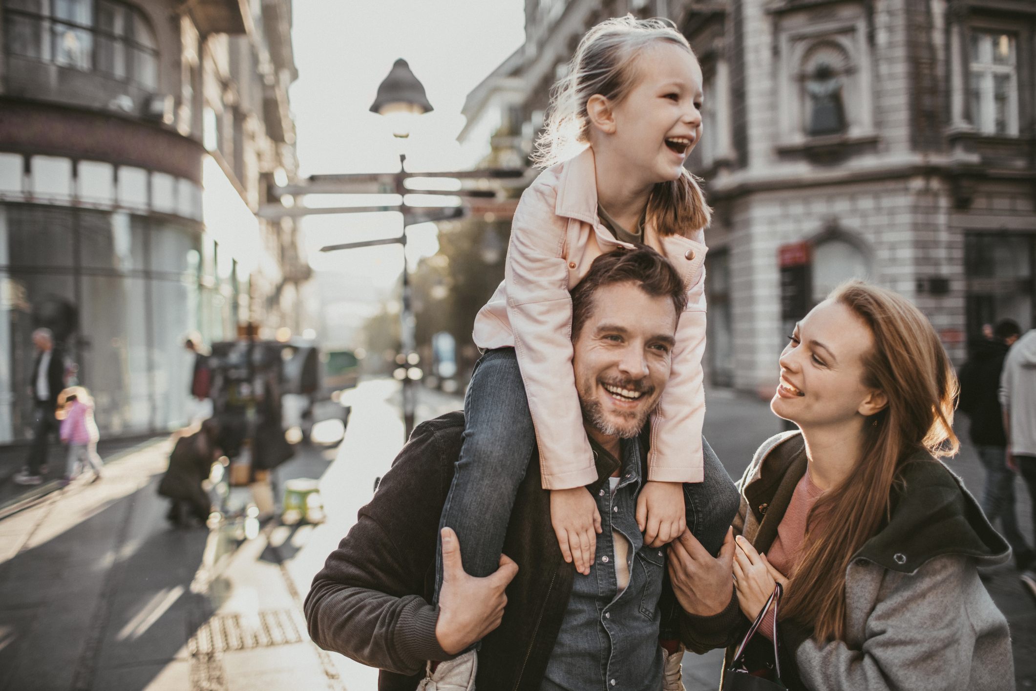 Happy, smiling woman outdoors shopping while dating a guy with kids.
