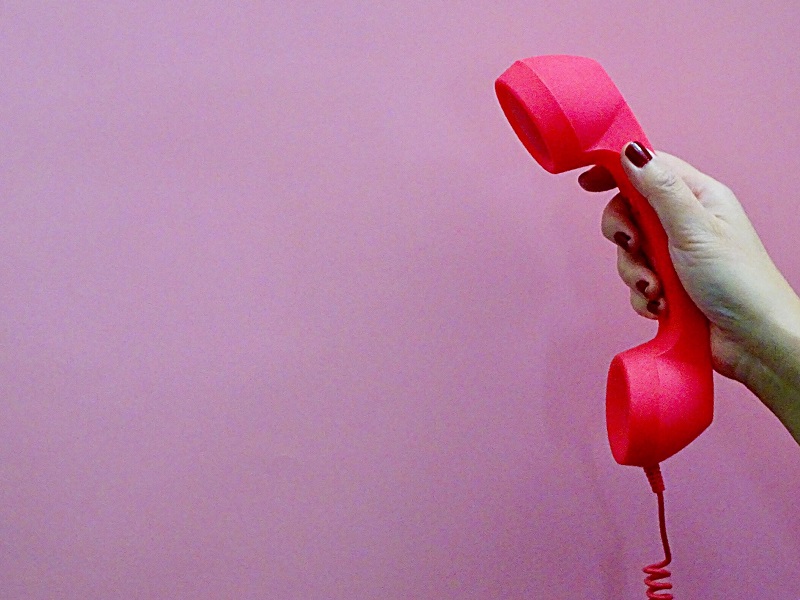 woman holding phone thinking about how to have phone sex