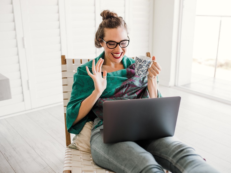 woman on video chat laughing while social distancing dating