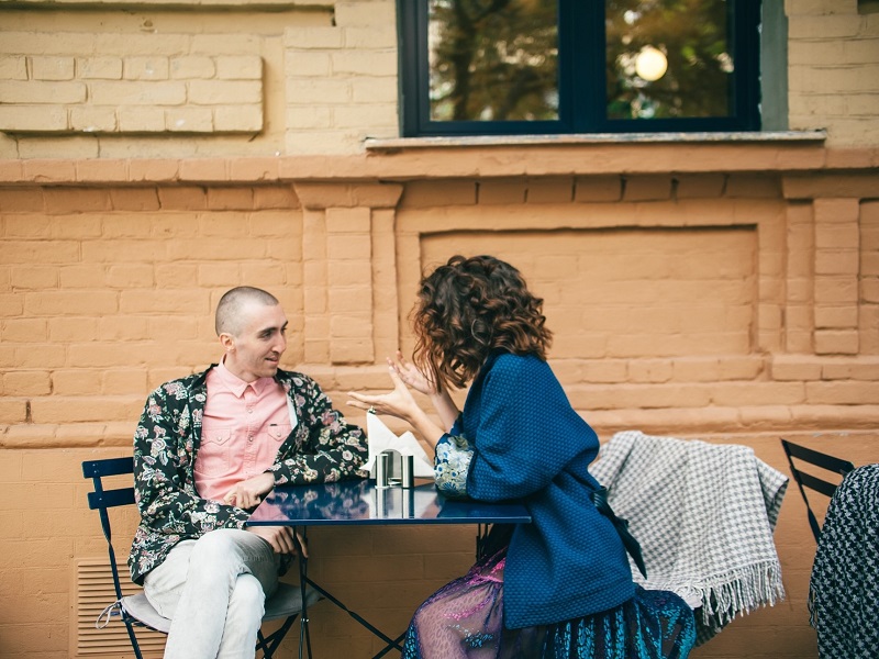 man and woman sitting at cafe table showing how to flirt with your crush