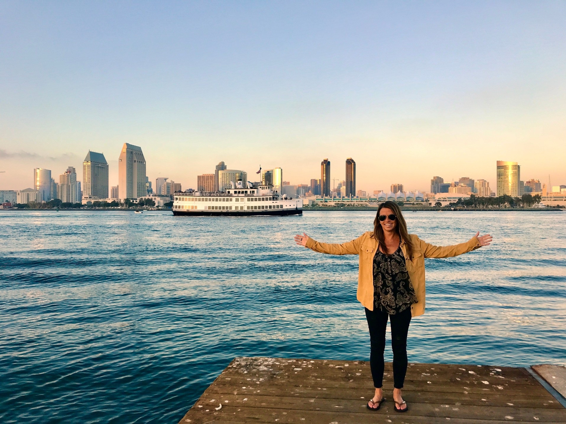 single woman standing in front of downtown San Diego ready to start dating
