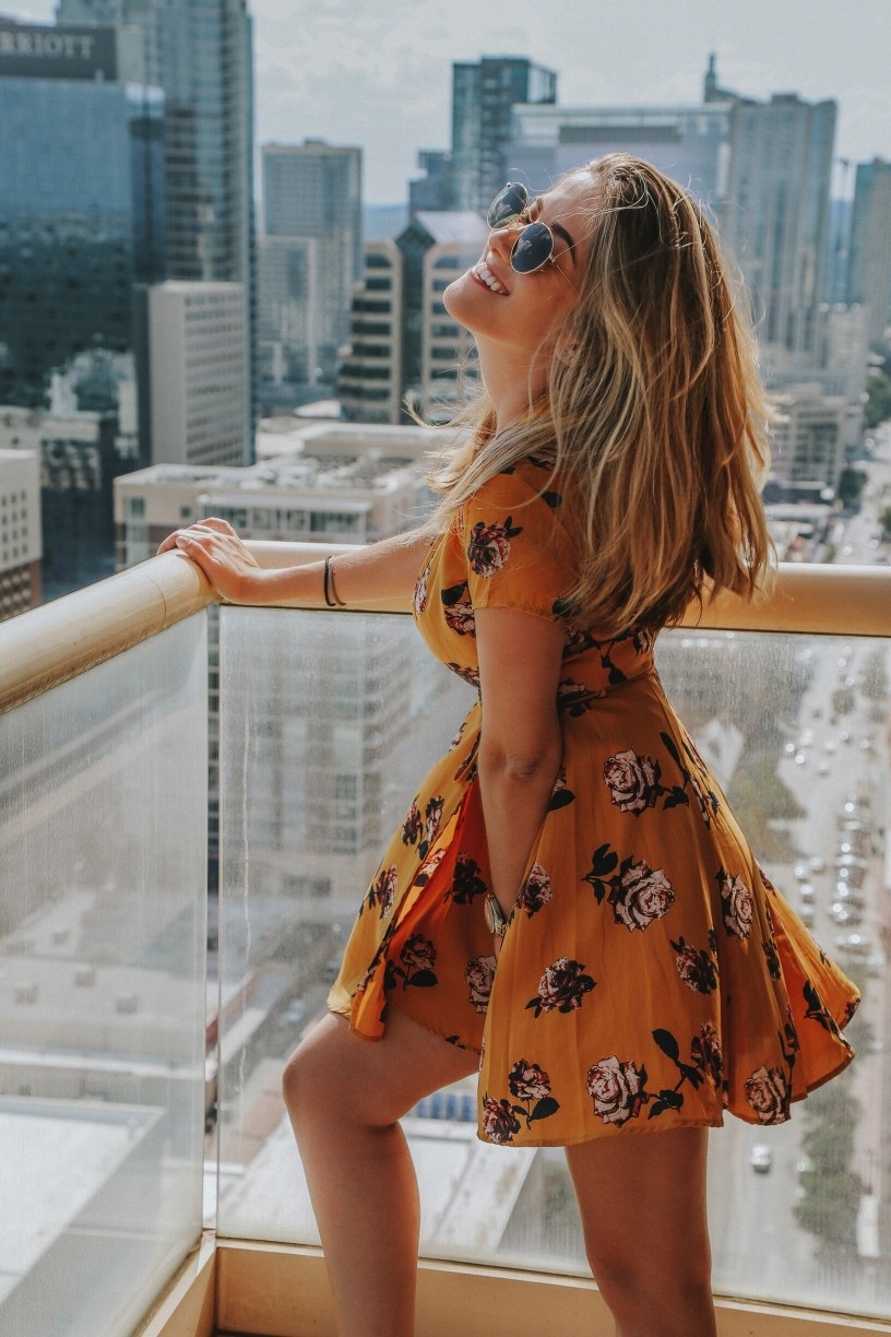 attractive single woman laughing on balcony in front of Austin skyline